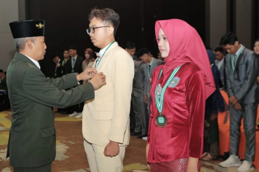 Kepala SMA Nahdlatul Ulama 1 Gresik, Drs H Agus Syamsudin, MA saat melakukan pelapasan atribut siswa secara simbolis dalam Wisuda ke 54. Foto: dok SMANU 1 Gresik/NUGres