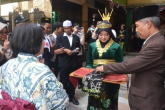 Kepala SMANU 1 Gresik Dr H Agus Syamsudin bersama jajaran guru serta peserta didik menyambut kehadiran native speaker dari Jepang, Senin (2/9/2024). Foto: dok SMANU 1 Gresik/NUGres