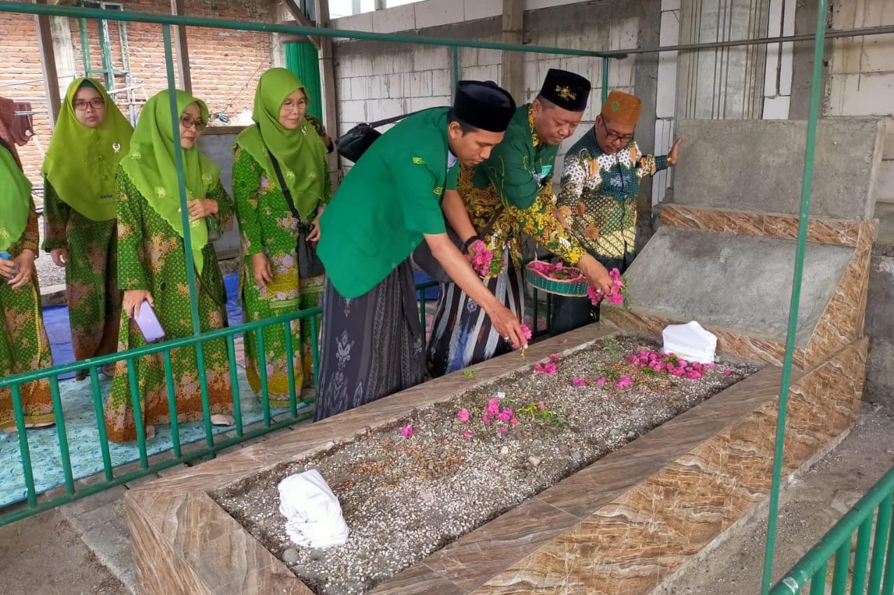 Ketua Tanfidziyah MWCNU Balongpanggang bersama Ketua PAC GP Ansor Balongpanggang menaburkan bunga di makbarah KH Atiq Ismail, salah seorang penggerak NU di Kecamatan Balongpanggang Gresik. Foto: dok MWCNU Balongpanggang/NUGres