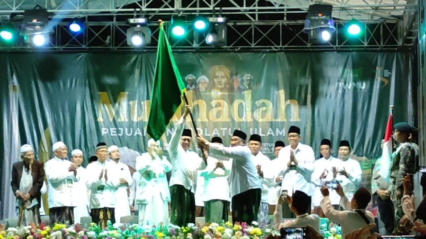 Rangkaian Mujahadah Pejuang NU pada Sabtu (9/11/2024) malam, di Gedung Hofdbestuur Nahdlatoel Oelama (HBNO) juga diwarnai momen penyerahan pataka Bendera Nahdlatul Ulama yang diterima oleh Ketua PWNU Jawa Timur KH Kikin Abdul Hakim Mahfudz. Foto: NUGres