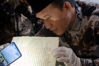 Prof Oman Fathurahman, salah satu guru besar filologi Indonesia kala melihat koleksi manuskrip para muassis Pondok Pesantren Qomaruddin Bungah Gresik. Foto: dok Qomaruddin Media/NUGres