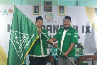 Ketua PAC GP Ansor Ujungpangkah masa khidmat 2022 - 2024 Rizal Arifianto (kanan), menyerahkan bendera panji GP Ansor kepada Ahmad Mahdi (kiri) seusai terpilih secara aklamasi sebagai Ketua PAC GP Ansor Ujungpangkah masa khidmat 2025 - 2028 pada Konferansi Anak Cabang Ujungpangkah ke-IX, Jumat (17/1/2025). Foto: dok PAC GP Ansor Ujungpangkah/NUGres