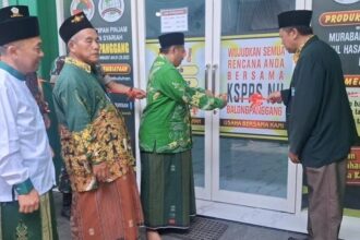 Ketua Tanfidziyah PCNU Gresik Dr. KH. Mulyadi MM., melakukan pengguntingan pita dalam peluncuran Koperasi NU Balongpanggang, Ahad (26/1/2025). Foto: dok MWCNU Balongpanggang/NUGres