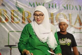 Anggota Muslimat NU Sidayu, Masbaha, saat bertugas sebagai MC di acara "MWCNU Sidayu Bersholawat". Foto: dok MWCNU Sidayu/NUGres