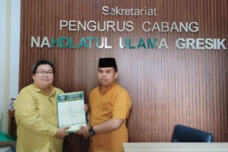 Ketua Pengurus Cabang Lembaga Falakiyah Nahdlatul Ulama (LFNU) Gresik, Ustadz Muchyiddin Hasan (kiri) menyerahkan secara simbolis jadwal imsakiyah ke PCNU Gresik, Selasa (18/2/2025). Foto: dok PC LFNU Gresik/NUGres