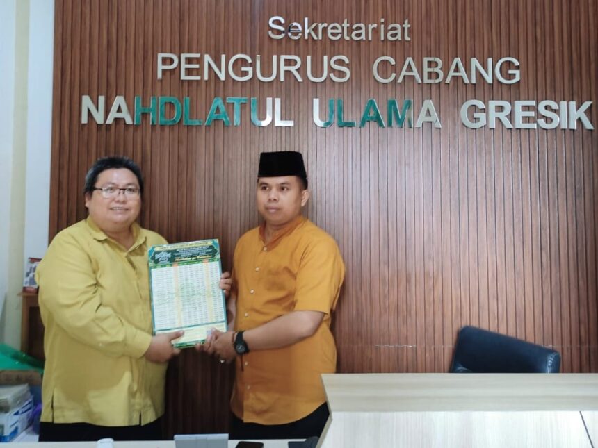 Ketua Pengurus Cabang Lembaga Falakiyah Nahdlatul Ulama (LFNU) Gresik, Ustadz Muchyiddin Hasan (kiri) menyerahkan secara simbolis jadwal imsakiyah ke PCNU Gresik, Selasa (18/2/2025). Foto: dok PC LFNU Gresik/NUGres