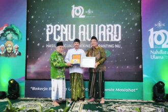 Pj Rais Syuriyah PCNU Gresik KH Moh. Farhan, bersama Wakil Bupati Gresik dr Asluchul Alif, menyerahkan piagam penghargaan kepada Juara Umum MWCNU, dalam PCNU Gresik Award Tahun 2025, Sabtu (22/2/2025). Foto: Jalil/NUGres