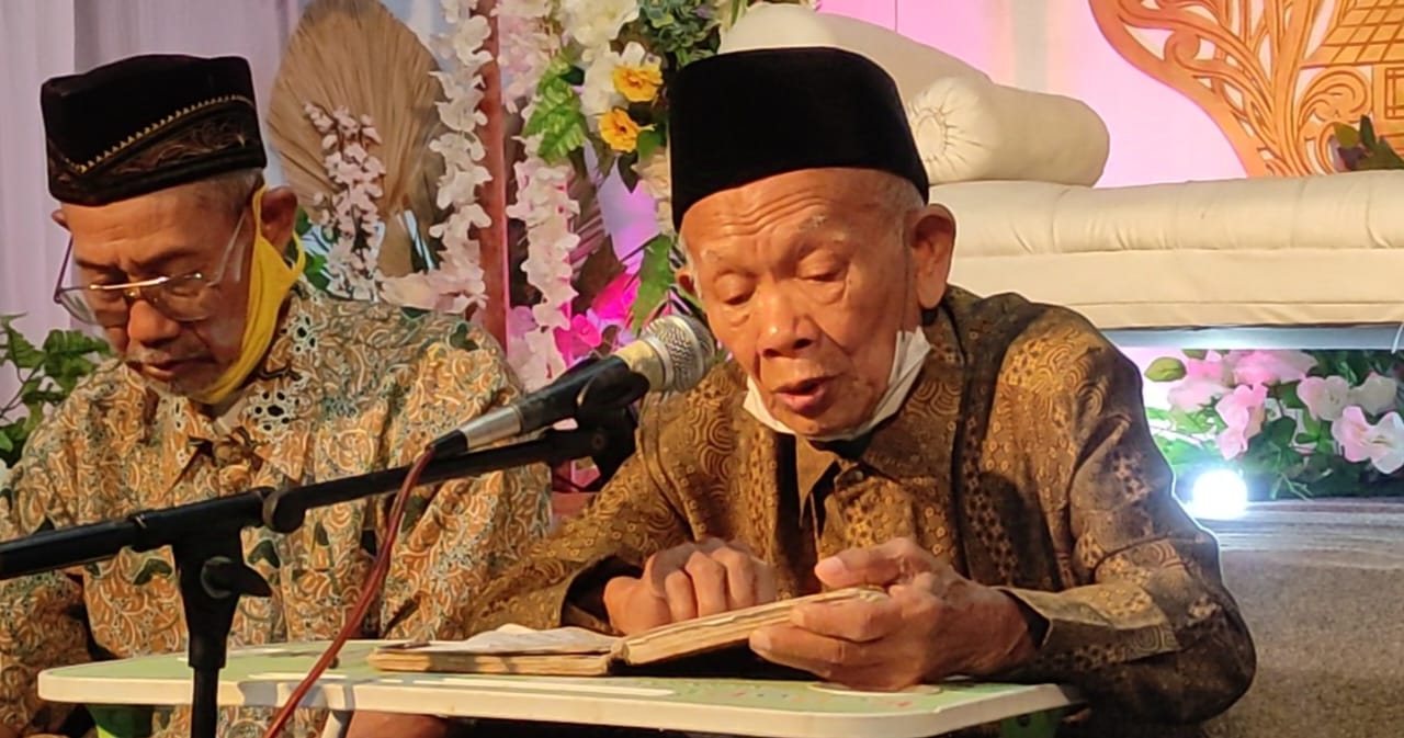 Mbah Mat Kauli, didampingi dengan sahabat dekatnya Sumarmo, saat menembangkan Macapat dengan cengkok khas Gresikan di suatu acara pra-resepsi pernikahan, pada 6 Juli 2023 silam. Foto: dok Chidir/NUGres